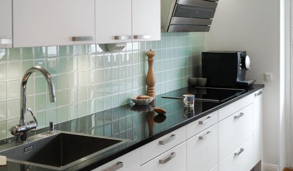 Klassiskt vitt kök med svart bänkskiva